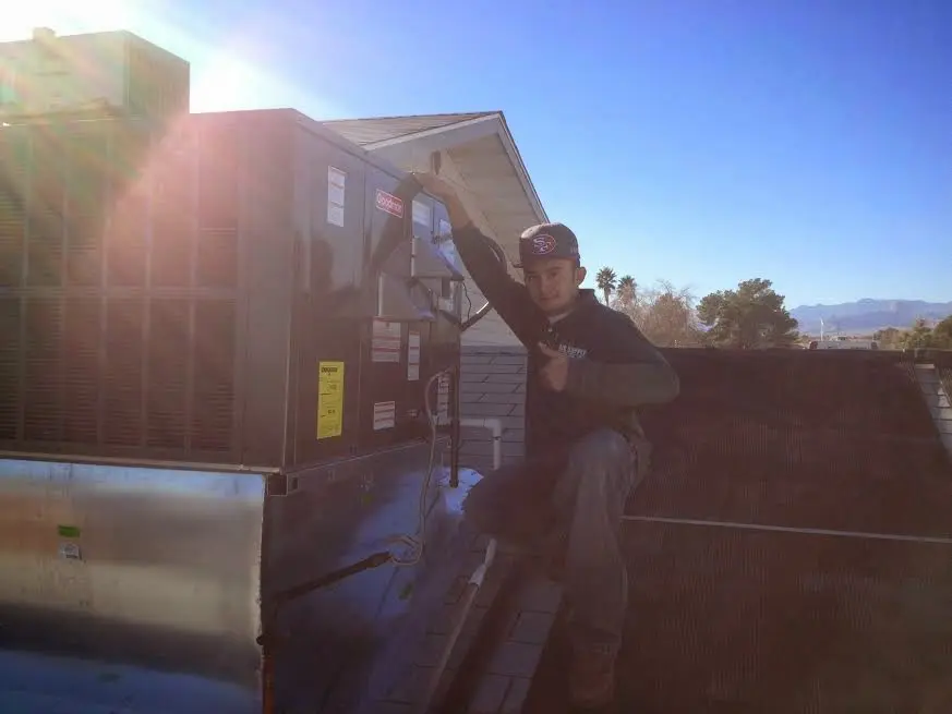 HVAC technician performing Air Duct Repair on a rooftop unit in East Bethel